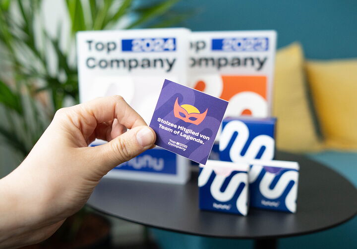 Hand, die einen Sticker von Kununu in der Hand hält